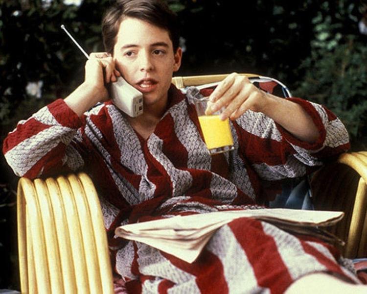 Man in striped pyjamas sipping orange juice sitting down outside
